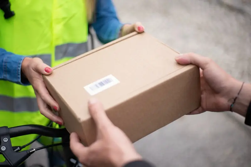 Entrega de un paquete en mano a un cliente