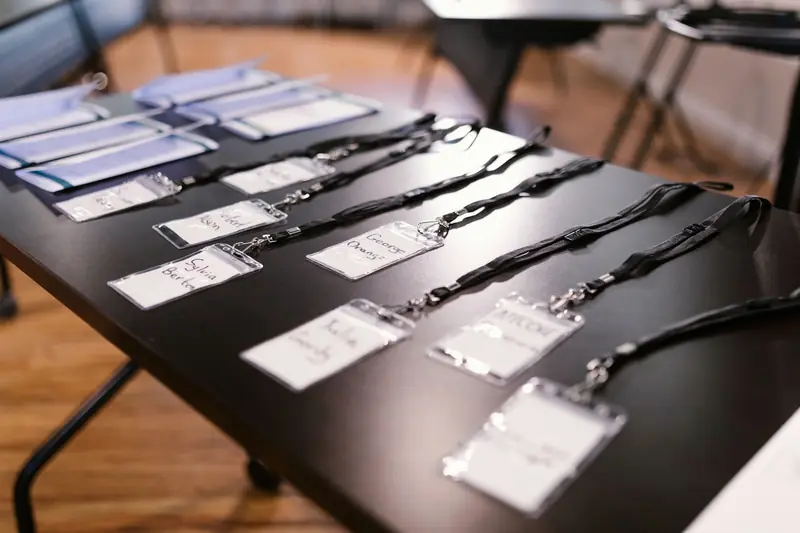 Cintas con porta credenciales ordenadas sobre una mesa de evento