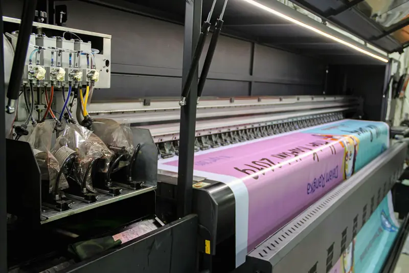 Plotter de gran formato imprimiendo una gigantografía en lona