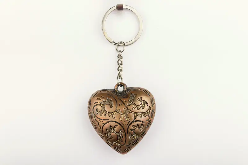 Llavero de metal en forma de corazón sobre fondo blanco